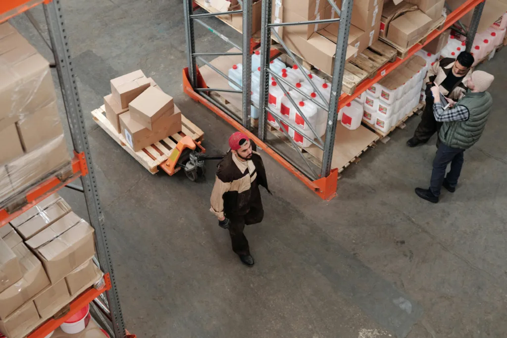 logstics 8 Team working in an industrial warehouse discussing and organizing inventory with pallets.